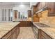 Gourmet kitchen boasts wooden cabinets, granite countertops, stainless steel appliances, and a window bringing in lots of light at 12809 W Oyer Ln, Peoria, AZ 85383