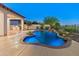 Inviting pool with rock waterfall and lush desert landscaping, plus a covered patio with outdoor kitchen at 12809 W Oyer Ln, Peoria, AZ 85383