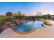 Inviting pool featuring a rock waterfall and mature desert landscaping, creating a serene outdoor oasis at 12809 W Oyer Ln, Peoria, AZ 85383