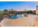 Backyard view of sparkling pool with waterfall feature, surrounded by lush landscaping and a spacious patio area at 12809 W Oyer Ln, Peoria, AZ 85383
