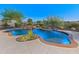 Beautiful backyard pool with rock waterfall feature surrounded by lush desert landscaping at 12809 W Oyer Ln, Peoria, AZ 85383