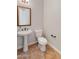 Traditional powder room featuring a pedestal sink, toilet, and decorative mirror at 12809 W Oyer Ln, Peoria, AZ 85383