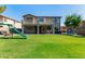 Large backyard with a play set, green grass, and a covered patio area for outdoor living at 1342 E Jade Dr, Chandler, AZ 85286