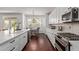 Bright eat-in kitchen featuring white cabinets, stainless steel appliances and hardwood floors at 1342 E Jade Dr, Chandler, AZ 85286