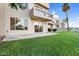 Backyard patio with green grass, patio furniture and community lake view at 1414 W Coral Reef Dr, Gilbert, AZ 85233