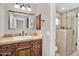 Elegant bathroom featuring a vanity with granite countertops, framed mirror, and a tiled shower at 1414 W Coral Reef Dr, Gilbert, AZ 85233