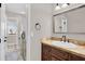 Stylish bathroom featuring a granite vanity with bronze fixtures, framed mirror, and tiled shower with glass door at 1414 W Coral Reef Dr, Gilbert, AZ 85233
