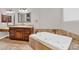 Bright bathroom features a soaking tub, tile surround, and wooden vanity with granite countertops at 1414 W Coral Reef Dr, Gilbert, AZ 85233