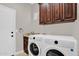 Functional laundry room with modern washer, dryer, sink and dark wood cabinetry at 1414 W Coral Reef Dr, Gilbert, AZ 85233