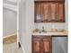A wet bar has wooden cabinets, granite countertops, and a refrigerator at 1414 W Coral Reef Dr, Gilbert, AZ 85233