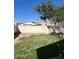 Backyard featuring a retaining wall, a tree and a section of grass at 15088 N 85Th Dr, Peoria, AZ 85381