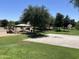 Community park featuring a basketball court, playground, grassy areas, and shaded seating for outdoor activities at 15731 W Evans Dr, Surprise, AZ 85379