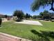 Community park featuring a basketball court, playground, grassy areas, and shaded seating for outdoor activities at 15731 W Evans Dr, Surprise, AZ 85379
