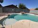 Refreshing pool with rock waterfall feature and tanning ledge in a private backyard oasis, perfect for relaxation and entertaining at 15731 W Evans Dr, Surprise, AZ 85379