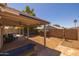 A backyard with a covered patio, lawn, and small trees at 15737 W Lundberg St, Surprise, AZ 85374