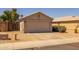 Home exterior featuring a two-car garage, desert landscaping, and a private, fenced side yard at 15737 W Lundberg St, Surprise, AZ 85374