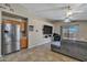Open-concept living room with modern furniture, tile floors, a ceiling fan, and a large television at 15737 W Lundberg St, Surprise, AZ 85374