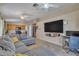Open-concept living area with a kitchen view, featuring tile floors, a sectional couch, and modern appliances at 15737 W Lundberg St, Surprise, AZ 85374
