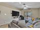 Cozy living area with tile floors, a modern entertainment center, and natural light, offering a relaxing ambiance at 15737 W Lundberg St, Surprise, AZ 85374