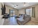 Comfortable living room with a large sectional couch, tile flooring, and a sliding glass door to the backyard at 15737 W Lundberg St, Surprise, AZ 85374