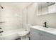 Modern bathroom with a shower-tub combo, gray vanity, and white marbled tile surround at 17228 N 16Th Dr # 3, Phoenix, AZ 85023