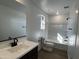 Modern bathroom features a shower-tub, dark fixtures, and a sleek vanity with ample counter space at 17535 W Fulton St, Goodyear, AZ 85338
