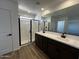 Bathroom with double sink vanity, a walk-in shower with black trim, and wood-look tile flooring at 17535 W Fulton St, Goodyear, AZ 85338