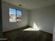 Cozy bedroom with plush carpet, white walls, and a large window offering a pleasant view at 17535 W Fulton St, Goodyear, AZ 85338