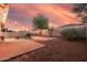 Inviting backyard featuring a brick patio, fire pit, string lights, desert landscaping, and block wall at 1783 W Cool Water Way, San Tan Valley, AZ 85144