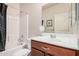 Bright bathroom featuring a single sink vanity with storage, a large mirror, and a shower-tub combo with modern fixtures at 1783 W Cool Water Way, San Tan Valley, AZ 85144