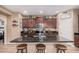 Modern kitchen with dark granite countertops, stainless steel appliances, and a center island with seating at 1783 W Cool Water Way, San Tan Valley, AZ 85144