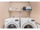 Well-organized laundry room with modern, side-by-side LG washer and dryer, and storage shelf, ideal for efficient laundry care at 1783 W Cool Water Way, San Tan Valley, AZ 85144