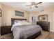 A primary bedroom features a ceiling fan, dark wood furniture, and stylish decor, creating a relaxing atmosphere at 1783 W Cool Water Way, San Tan Valley, AZ 85144