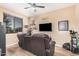Inviting Personal cave with comfortable reclining sofa, large screen TV, and decorative shelving, perfect for relaxation and entertainment at 1783 W Cool Water Way, San Tan Valley, AZ 85144