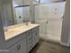 Bathroom featuring double sinks, white cabinets, modern fixtures, and a glass shower enclosure at 18340 W Patrick Ln, Surprise, AZ 85387