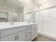 Bathroom with dual sinks, granite counters, large mirror, and glass shower at 18340 W Patrick Ln, Surprise, AZ 85387