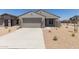 Charming single-story home featuring neutral stucco, a two-car garage, and desert landscaping on a sunny day at 18340 W Patrick Ln, Surprise, AZ 85387