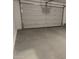 Spacious garage with a large white door and a sealed concrete floor at 18340 W Patrick Ln, Surprise, AZ 85387