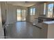 Open kitchen with stainless steel appliances, modern gray countertops, and glass sliding doors to the backyard at 18340 W Patrick Ln, Surprise, AZ 85387
