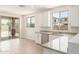 Bright kitchen featuring white cabinets, stainless steel appliances, gray countertops, and wood-look tile flooring at 18340 W Patrick Ln, Surprise, AZ 85387