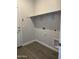 Efficient laundry area boasts a wood-look tile floor and built-in shelving for storage at 18340 W Patrick Ln, Surprise, AZ 85387