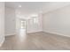 Spacious living room with neutral walls and wood-look tile flooring leading to the kitchen at 18340 W Patrick Ln, Surprise, AZ 85387