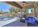 Inviting covered patio with comfortable seating, outdoor kitchen, and a view of the lush backyard at 19969 N Santa Cruz Dr, Maricopa, AZ 85138