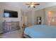 Serene primary bedroom with soft lighting, a large dresser, TV and a king-sized bed at 19969 N Santa Cruz Dr, Maricopa, AZ 85138