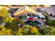 Aerial view of a backyard with a pool, jacuzzi, covered patio, outdoor seating, lush landscaping, and mature trees at 2058 E Marlene Dr, Gilbert, AZ 85296