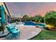 Expansive backyard featuring a pool, spa, covered patio with seating, and lush greenery, perfect for entertaining and relaxation at 2058 E Marlene Dr, Gilbert, AZ 85296
