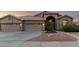 Single-story home with a terracotta roof, arched entry, and three-car garage, and low-maintenance desert landscaping at 2058 E Marlene Dr, Gilbert, AZ 85296