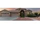 Single-story home with a terracotta roof, arched entry, three-car garage, and desert landscaping at 2058 E Marlene Dr, Gilbert, AZ 85296