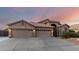 Inviting single-story home with a terracotta roof, arched entry, three-car garage, and desert landscaping at 2058 E Marlene Dr, Gilbert, AZ 85296