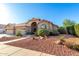 Beautiful single-story home boasts arched entry, three-car garage, terracotta roof, and desert landscaping at 2058 E Marlene Dr, Gilbert, AZ 85296